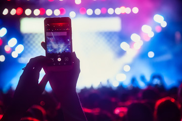 Fototapeta na wymiar People taking photographs with touch smart phone during a music entertainment public concert