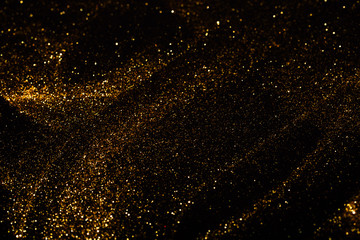Obraz premium Splash of golden sparkles on black background.