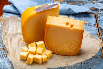 Aged and young Dutch Gouda cheese and cheese cubes blocks, tasty european food
