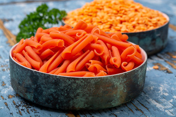 Orange gluten free diet pasta made from lentils  legumes on blue wooden table