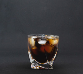 glass of whiskey with ice on black background