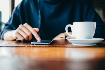 Woman in a cafe uses a mobile phone