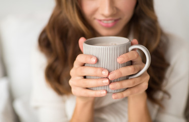 drink, christmas and hygge concept - close up of happy woman with cup of coffee at home