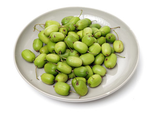 mini kiwi baby fruit (actinidia arguta) on white background