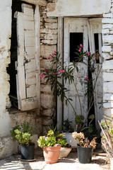 Fototapeta na wymiar Greece, the island of Folegandros. The historic capital of the island, the Hora. The oldest part of the Hora, the Kastro. A semi abandoned house, with flowers at it’s entrance