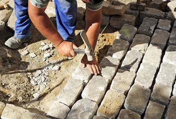 Traditional way of paving a Seville street with granite cobbles of Gerena