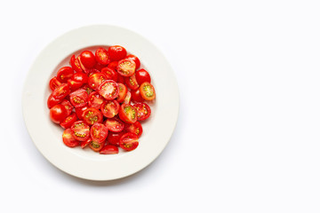 Fresh tomatoes, half cut on white dish.
