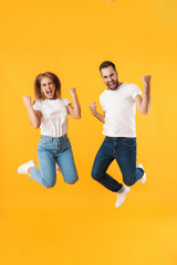 Image of happy couple jumping while celebrating victory