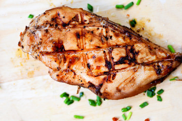 chicken breast grilled with herbs and spices on wooden cutting board top view - Roast BBQ chicken breast steak