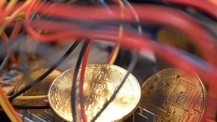 Bitcoin coins, colorful cables and printed circuit board PCB