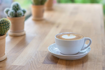 Coffee Mugs white plate on a wooden table  Background cactus..