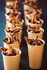 Tasty fried Garlic croutons snacks in paper bags. Street food marketing vertical image.