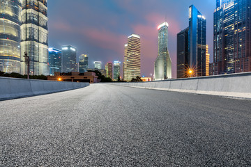 Shanghai modern commercial buildings and asphalt highway at night,China.