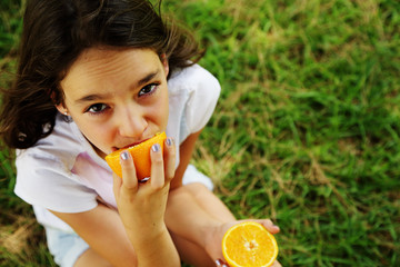 happy 12 year old girl smiling and holding orange slices