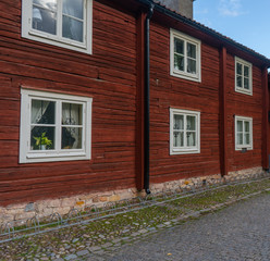 Fragment of old, wooden, red house and street. Orebro town. Travel photo. Background or illustration. 