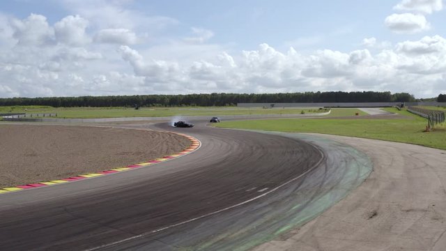 Drone view sport cars drifting on track while speed competition. Two japanese jdm car driving on racing track. Aerial side view from drone above driver riding on speed track
