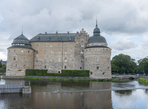 Orebro castle with clouds. Castle view from the pond side. Travel photo