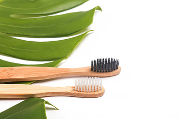 Bamboo brushes lying on green monstera leaf , close-up.