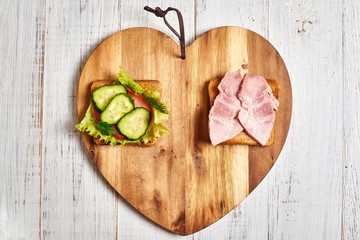 Sandwich with vegetables and a sandwich with meat. The choice between vegetarianism and meat-eating.