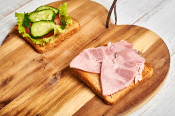 Sandwich with vegetables and a sandwich with meat. The choice between vegetarianism and meat-eating.