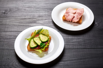 Sandwich with vegetables and a sandwich with meat. The choice between vegetarianism and meat-eating.