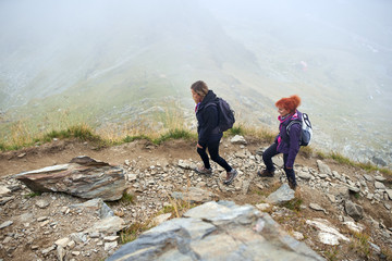 Backpacker ladies hiking on a trail