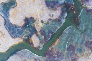 Aerial view of the frozen colourful lake melting because of the global warming.
