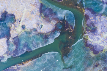 Fototapeta na wymiar Aerial view of the frozen colourful lake melting because of the global warming.