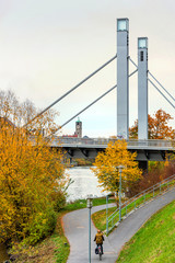Herbststimmung am Regnitzufer in Bamberg mit Radfahrer und Löwenbrücke