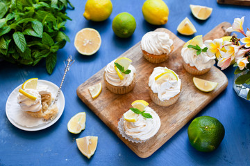 Fototapeta na wymiar Lemon cupcakes with poppy seeds, white butter cream and slice of lemon