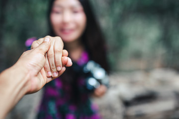 Travelers who hold hands smiling happily in their hands have cameras.