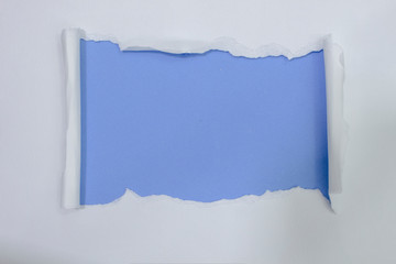 ripped white paper over blue color background