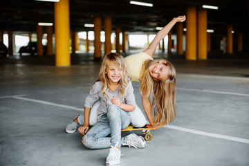Two beautiful girls having fun and playing in the parking lot. Street photo shoot