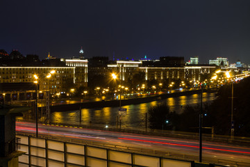 Fototapeta premium urban view of the railway via the metal bridge next to the freeway in the background of the night sky in Moscow Russia