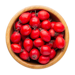 Hawthorn berries in wooden bowl isolated on white background. Top view.