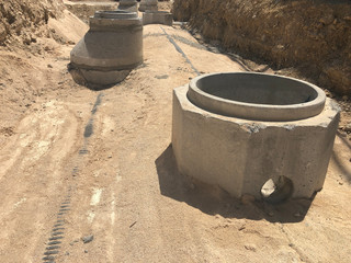 Storm water drainage reinforced concrete wells in the dug trench. Water drainage system under construction