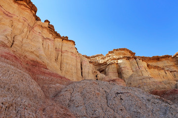 Fototapeta premium Yellow and red coloured cliffs of Tsagaan Suvraga «&nbsp;white stupa&nbsp;» in the Gobi desert on a bright sunny day, Dundgovi Province, Mongolia.