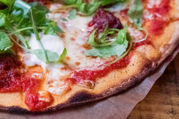 Delicious italian pizza with thin crust and fresh arugula
