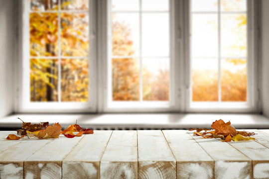 White wooden table and autumn leaves 