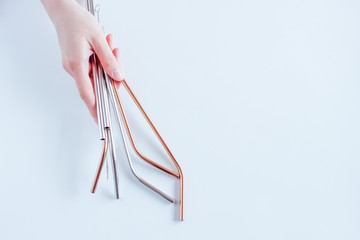 Metal straws in a hand on white background. Zero waste. Flat lay