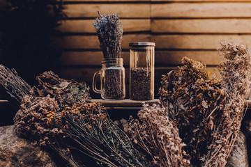 Dried herbs with glass jars on a wooden pool background. Copy space for text. Beauty blogger, salon...