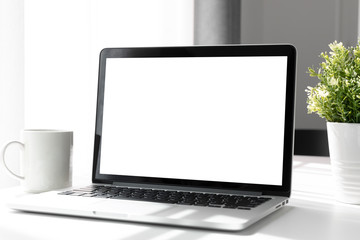 Fototapeta premium Komputer, laptop z pustym ekranem w domu tabeli, niewyraźne tło.