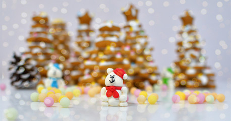 gingerbread Christmas tree.Christmas Gingerbread cookie with multi-colors caramel.Sugar white bears in red hat on white background next to multi-colors caramel