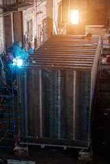 Welder collects a large metal container