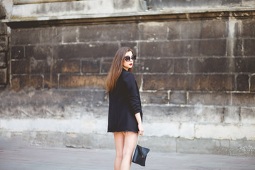 Fototapeta na wymiar Pretty young woman walks around the city in a stylish outfit