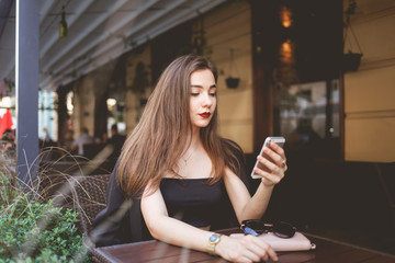 Beautiful girl uses a smartphone to communicate on the network. Portrait of a beautiful woman with a phone