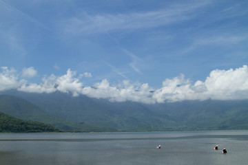 Women fishing for shellfish with rakes, Vietnam