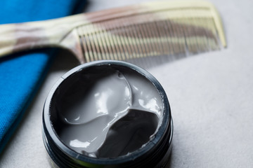 Hair wax and clay in tubs with comb