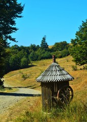 an old fountain near a dirt road