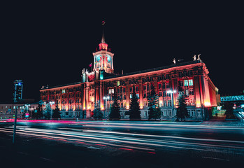 Light trails of passing cars in front of Yekaterinburg city hall at night with dark sky
